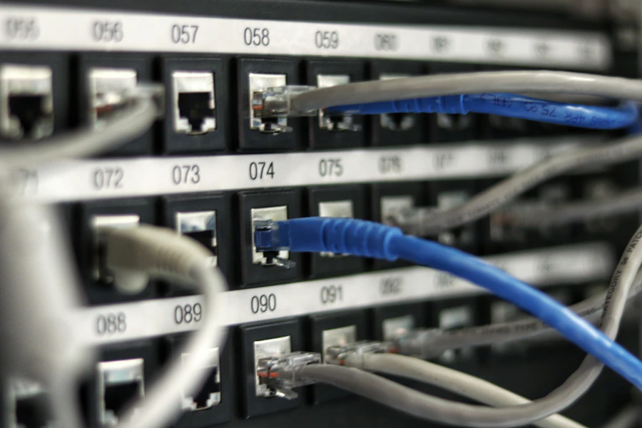 Sala de servidores com fileiras de racks e cabeamento organizado